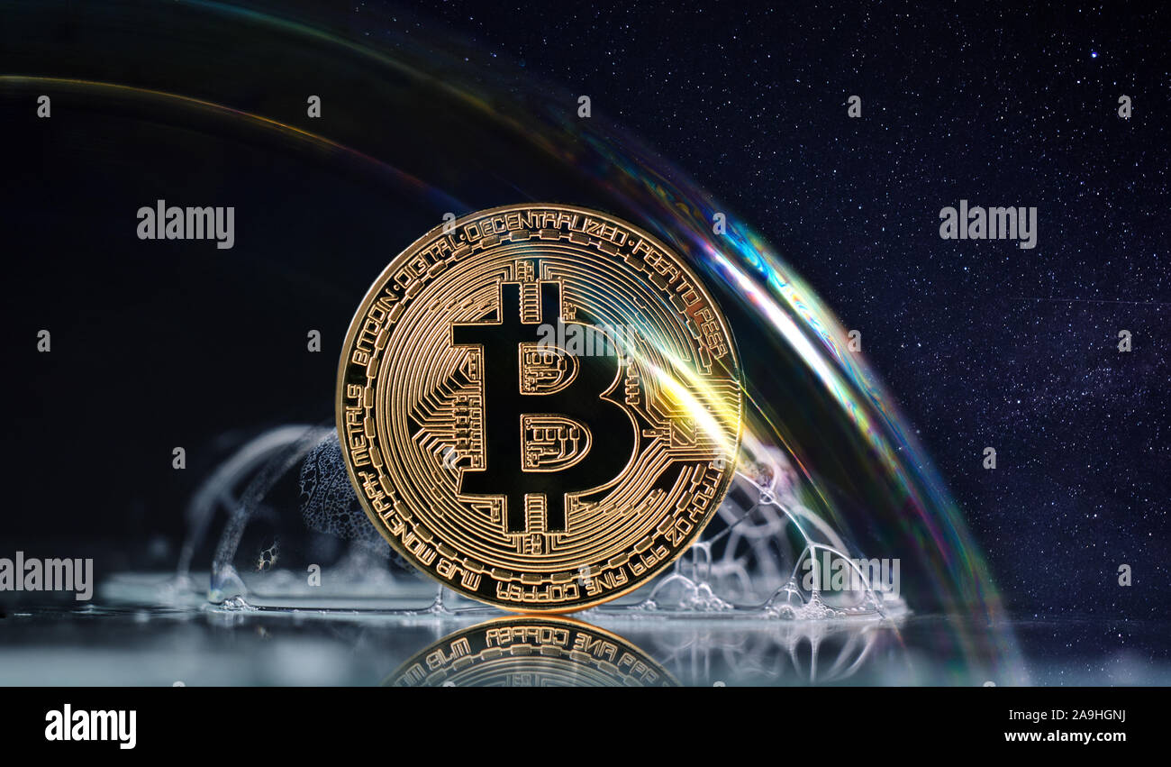 Physical Gold Bitcoin Coin in a Huge Soap Bubble Against Dark Background. Doubtful investment business with new cryptocurrency. Stock Photo