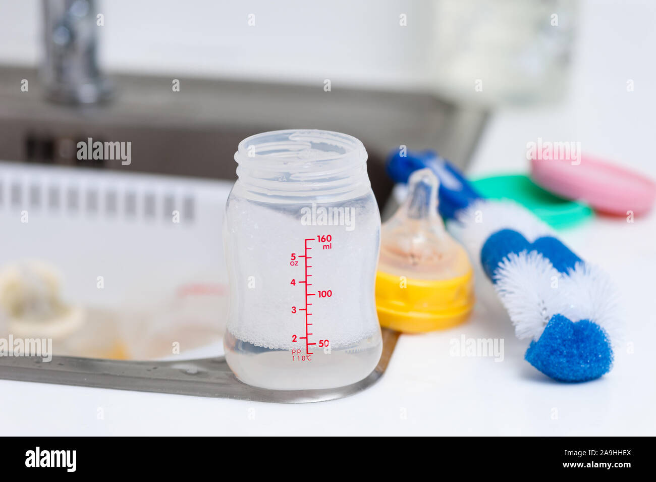 washing baby bottles and nipples with soft bottle brush and dishwashing