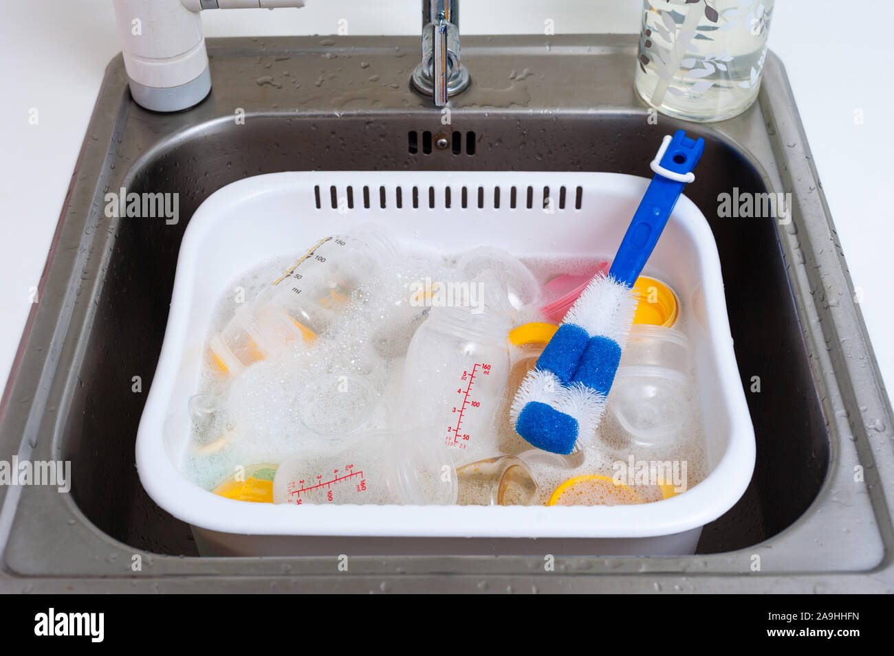 washing baby bottles and nipples with soft bottle brush and dishwashing