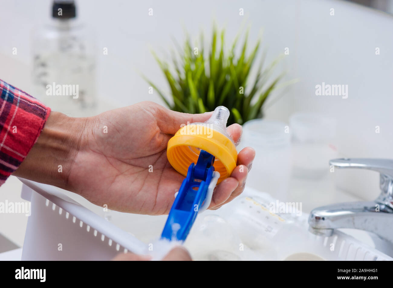 washing baby bottles and nipples with soft bottle brush and dishwashing