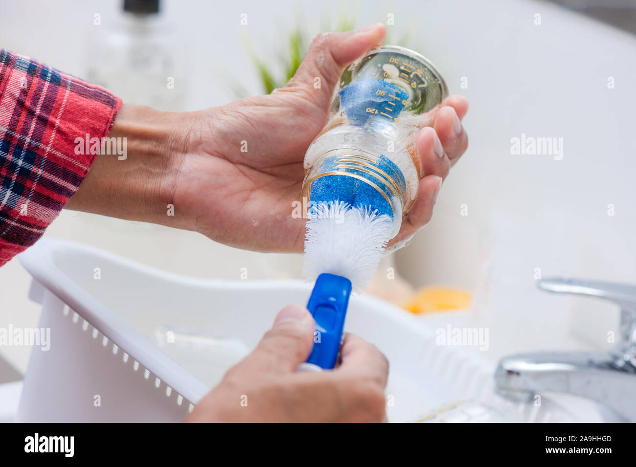washing baby bottles and nipples with soft bottle brush and dishwashing
