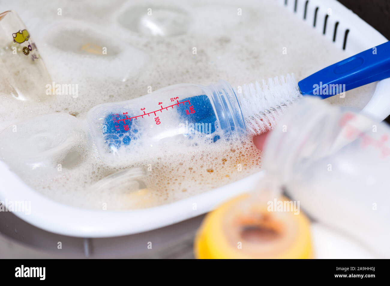washing baby bottles and nipples with soft bottle brush and dishwashing