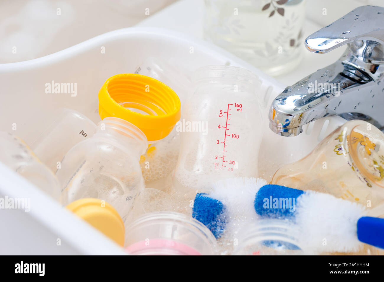 washing baby bottles and nipples with soft bottle brush and dishwashing