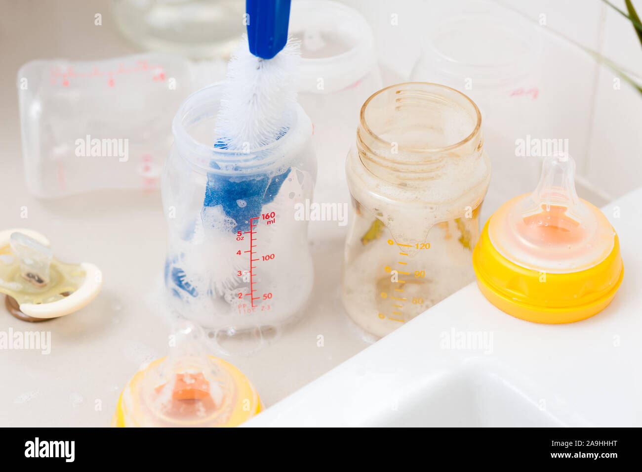 washing baby bottles and nipples with soft bottle brush and dishwashing