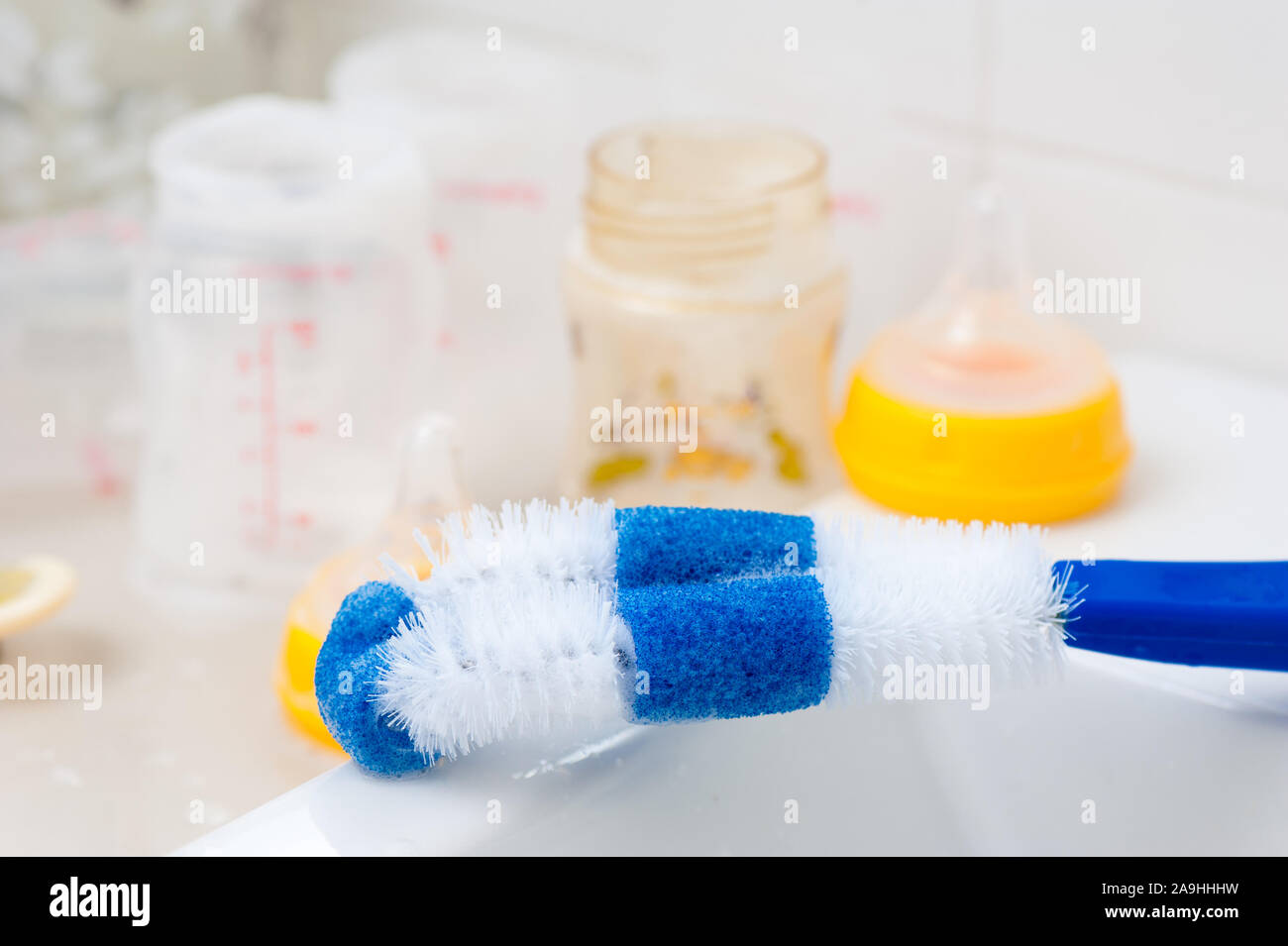 washing baby bottles and nipples with soft bottle brush and dishwashing