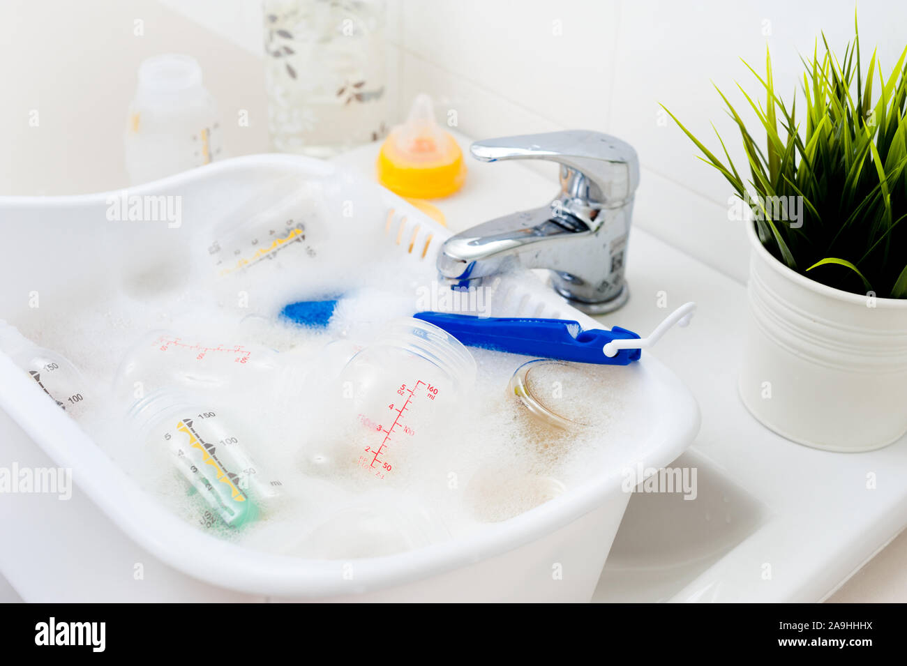 washing baby bottles and nipples with soft bottle brush and dishwashing
