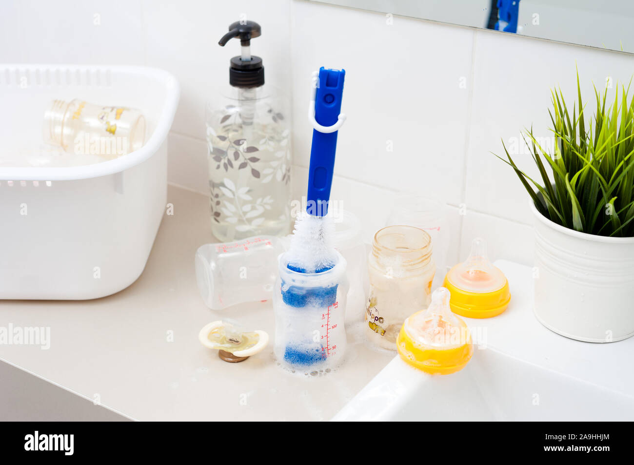 washing baby bottles and nipples with soft bottle brush and dishwashing