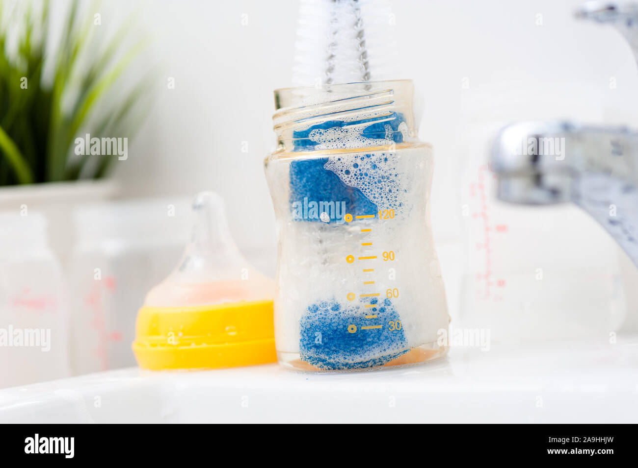 washing baby bottles and nipples with soft bottle brush and dishwashing