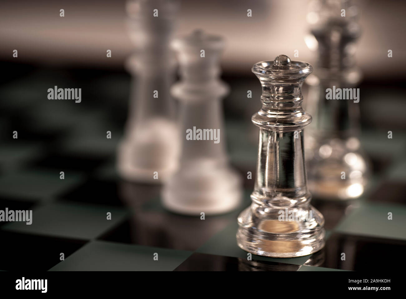 Pieces on a glass chess board - King, Knight, Queen Stock Photo