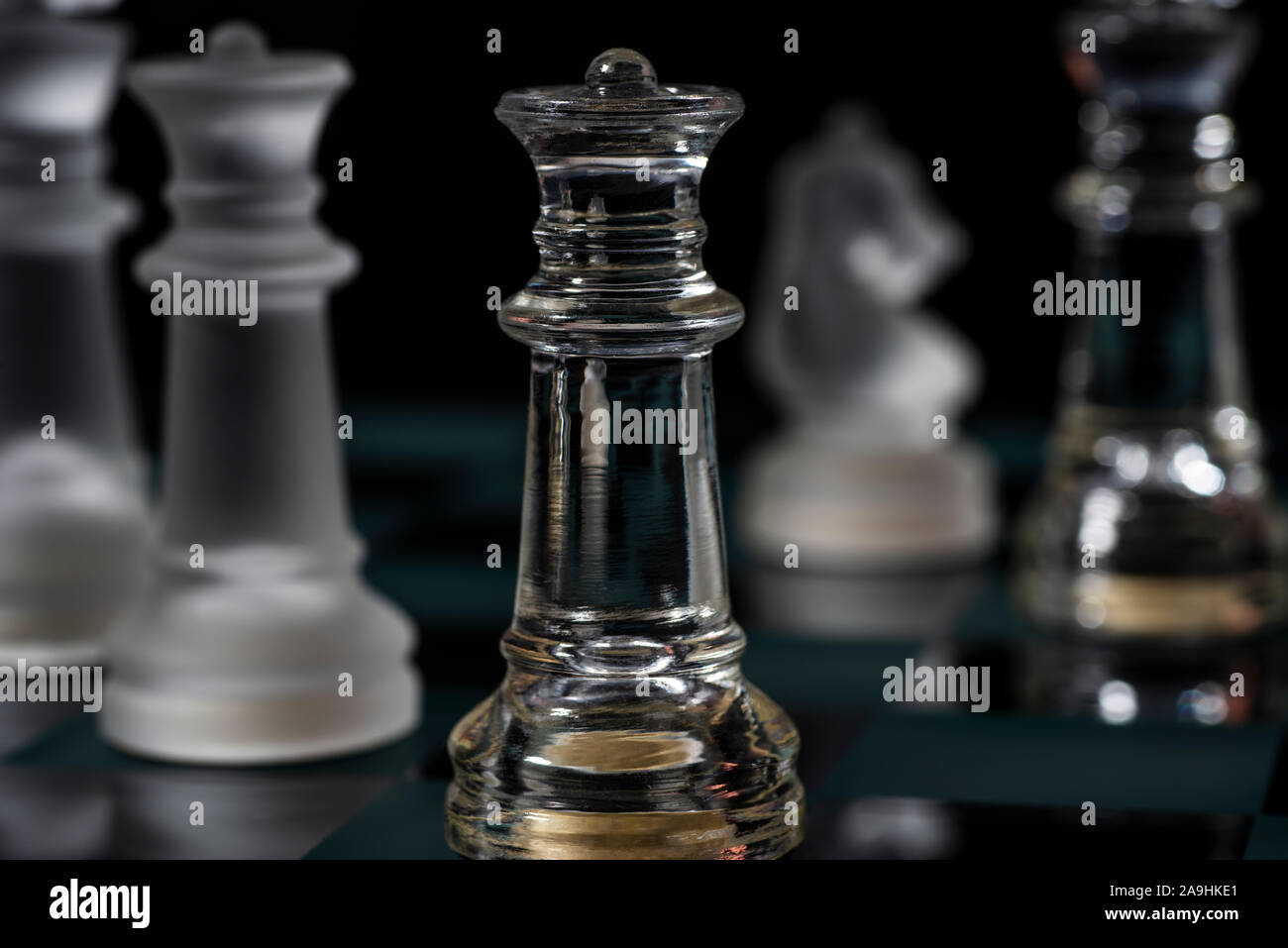 black glass queen chess piece on glass chess board Stock Photo - Alamy