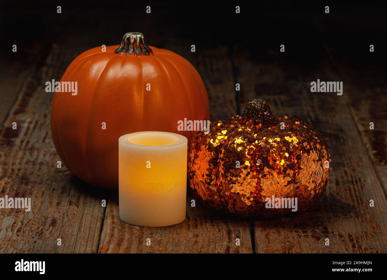 Halloween holiday still life of electric wax candle and pumpkins Stock Photo