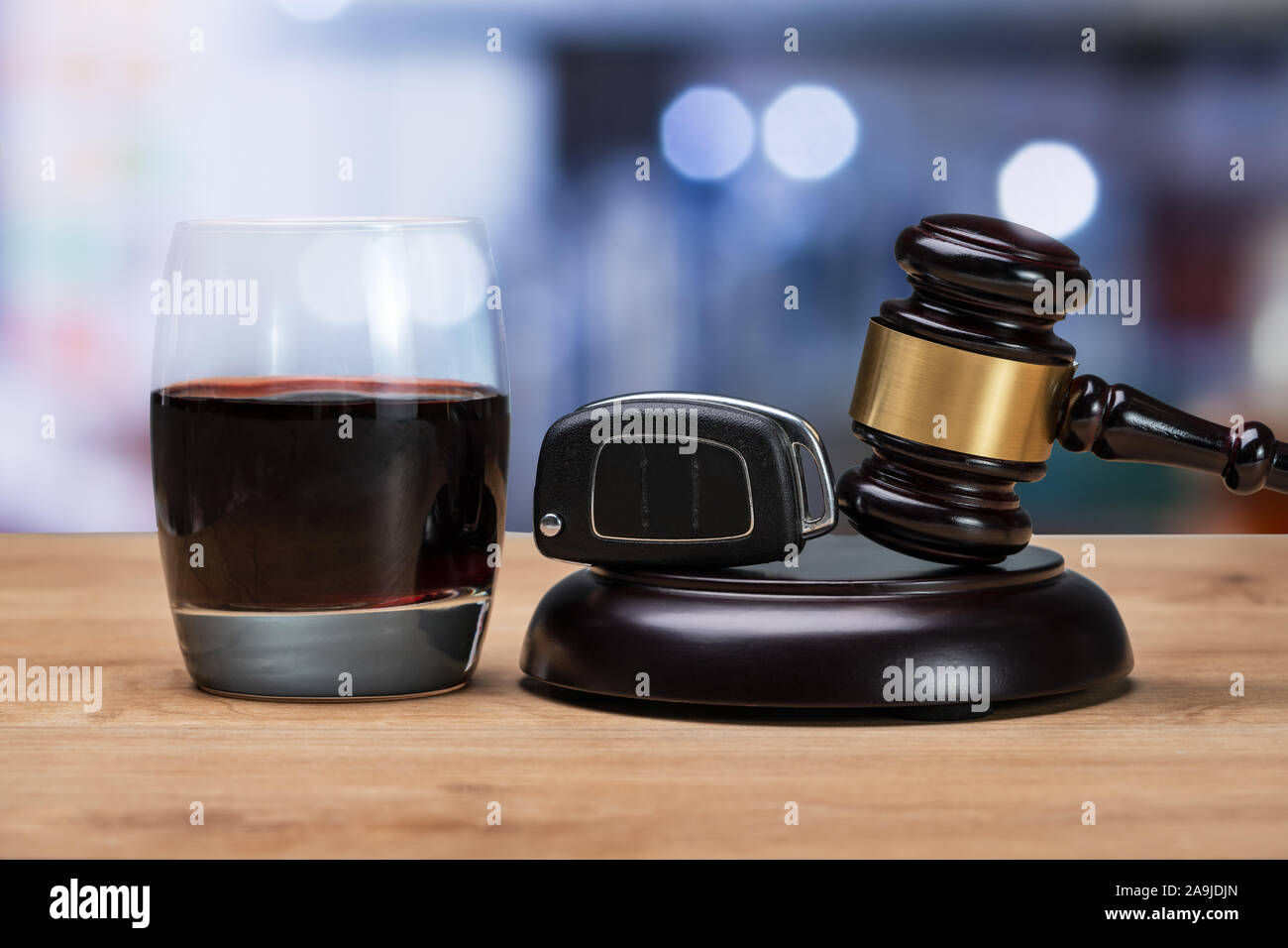 Car Key And Gavel Over Striking Block Near Glass Of Alcohol In Court Room Stock Photo