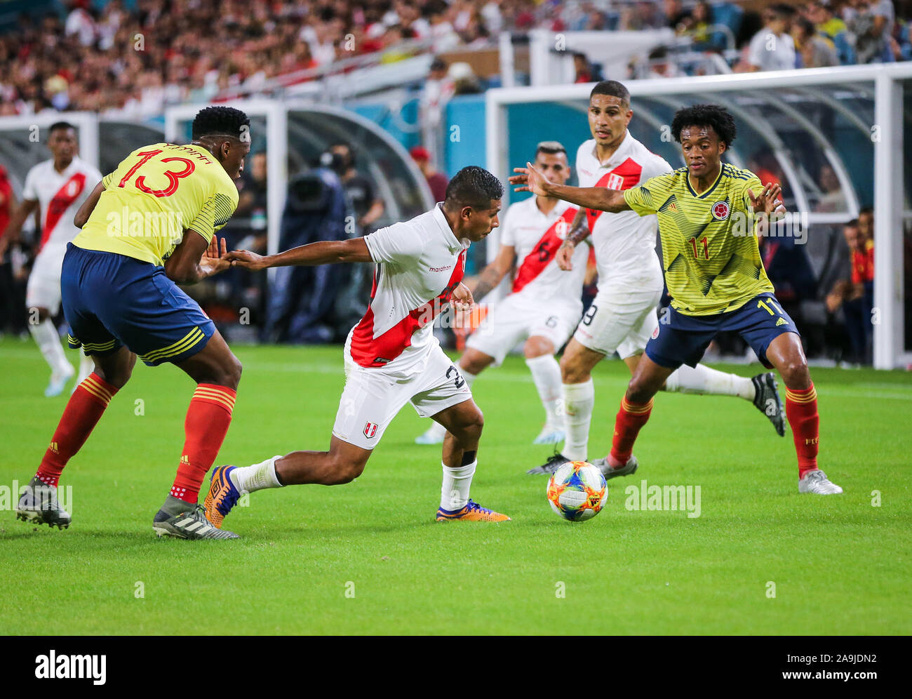 Miami Gardens, Florida, USA. 15th Nov, 2019. Peru midfielder Edison Flores (20) moves the ball challenged by Colombia midfielder Juan Cuadrados (11) and defender Yerry Mina (13) during a friendly soccer match at the Hard Rock Stadium in Miami Gardens, Florida. Credit: Mario Houben/ZUMA Wire/Alamy Live News Stock Photo