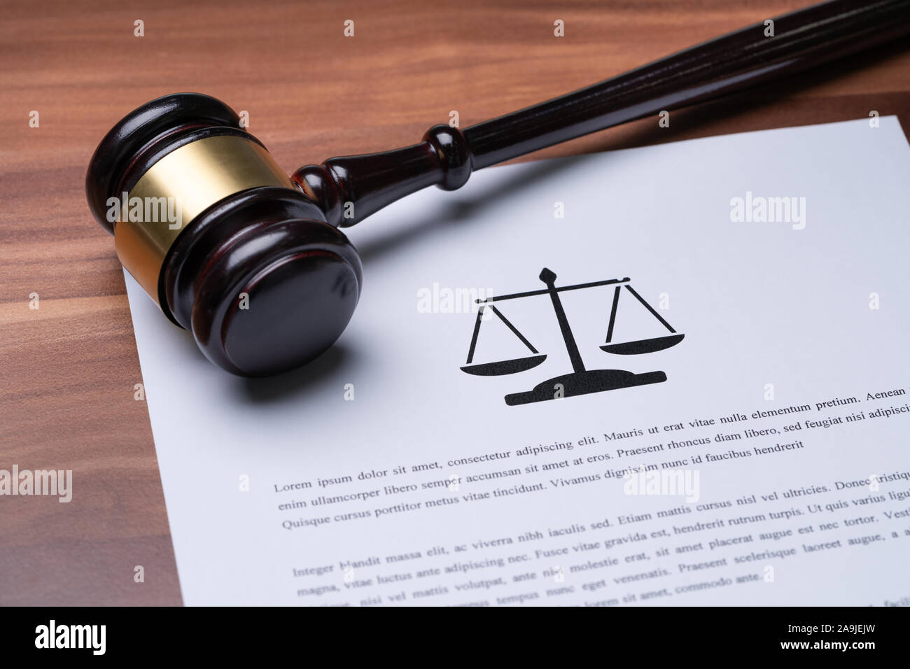 Close-up Of Judge Gavel Over Papers Of Law On Wooden Table Stock Photo