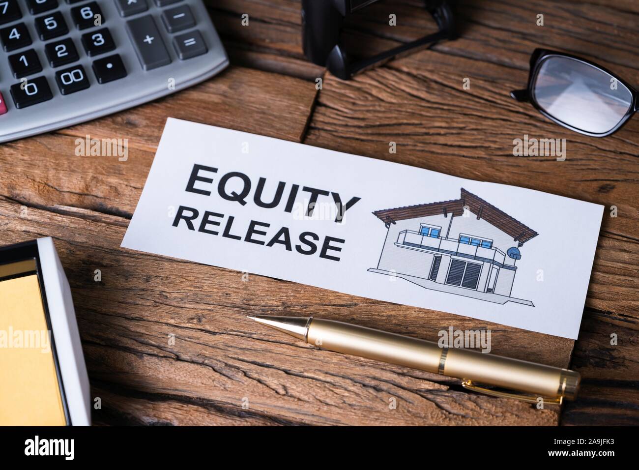 Overhead View Of Equity Release Text On Paper With A Colored House Near Office Supplies Stock Photo