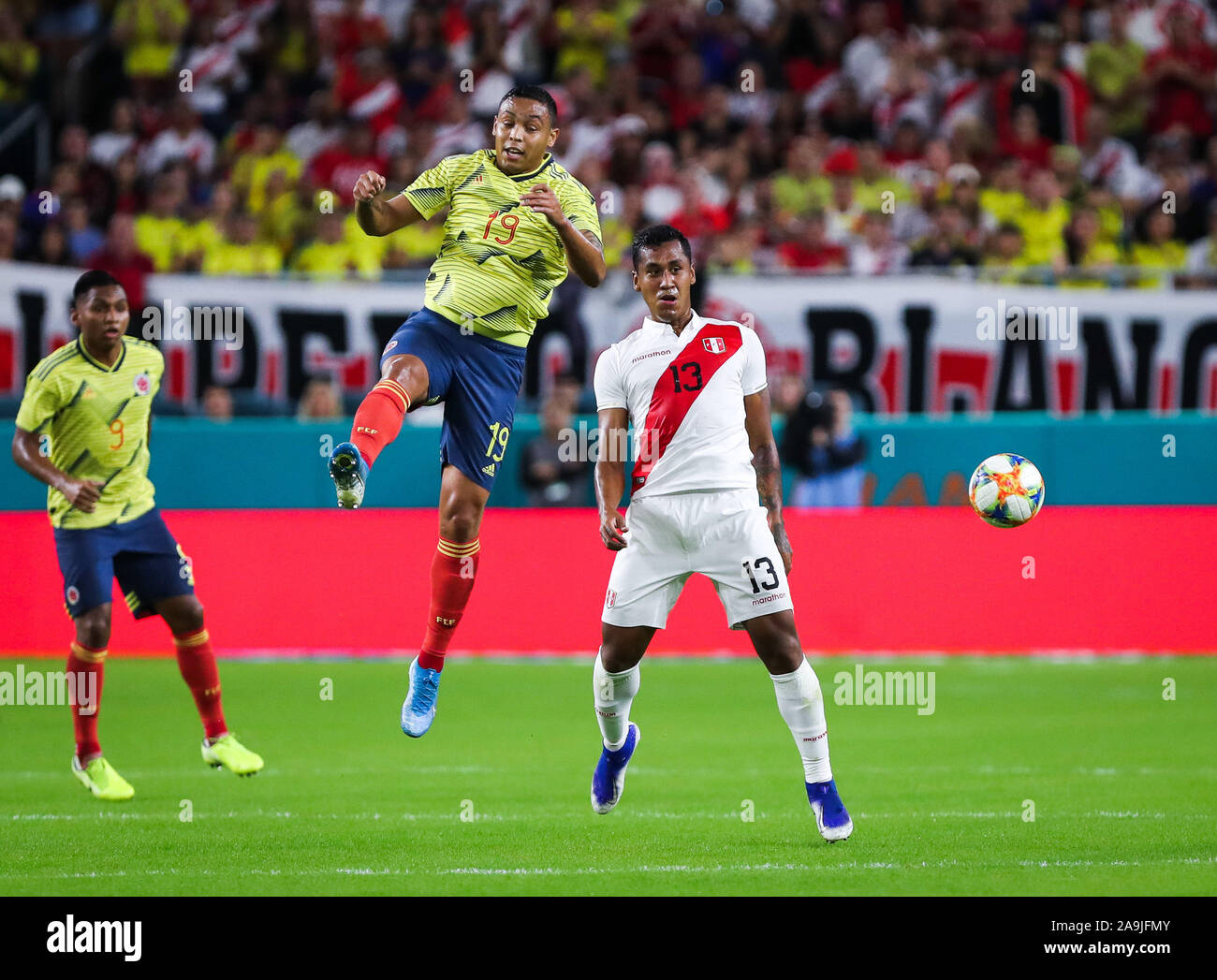 Miami Gardens, Florida, USA. 15th Nov, 2019. Colombia forward Luis Muriel (19) passes the ball with a header over Peru midfielder Renato Tapia (13) during a friendly soccer match at the Hard Rock Stadium in Miami Gardens, Florida. Credit: Mario Houben/ZUMA Wire/Alamy Live News Stock Photo
