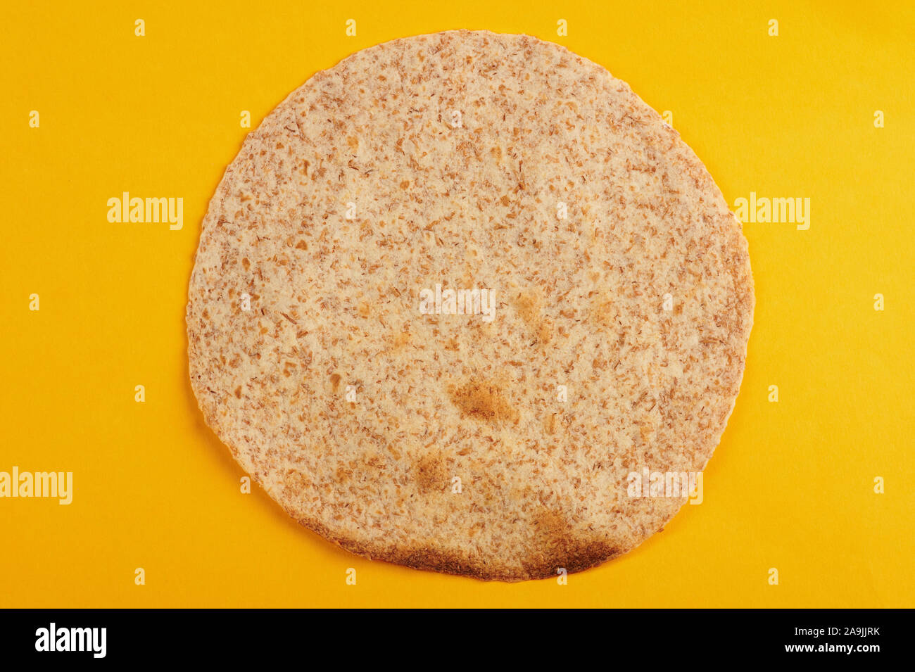 One tortilla for taco above top view isolated on yellow background Stock Photo