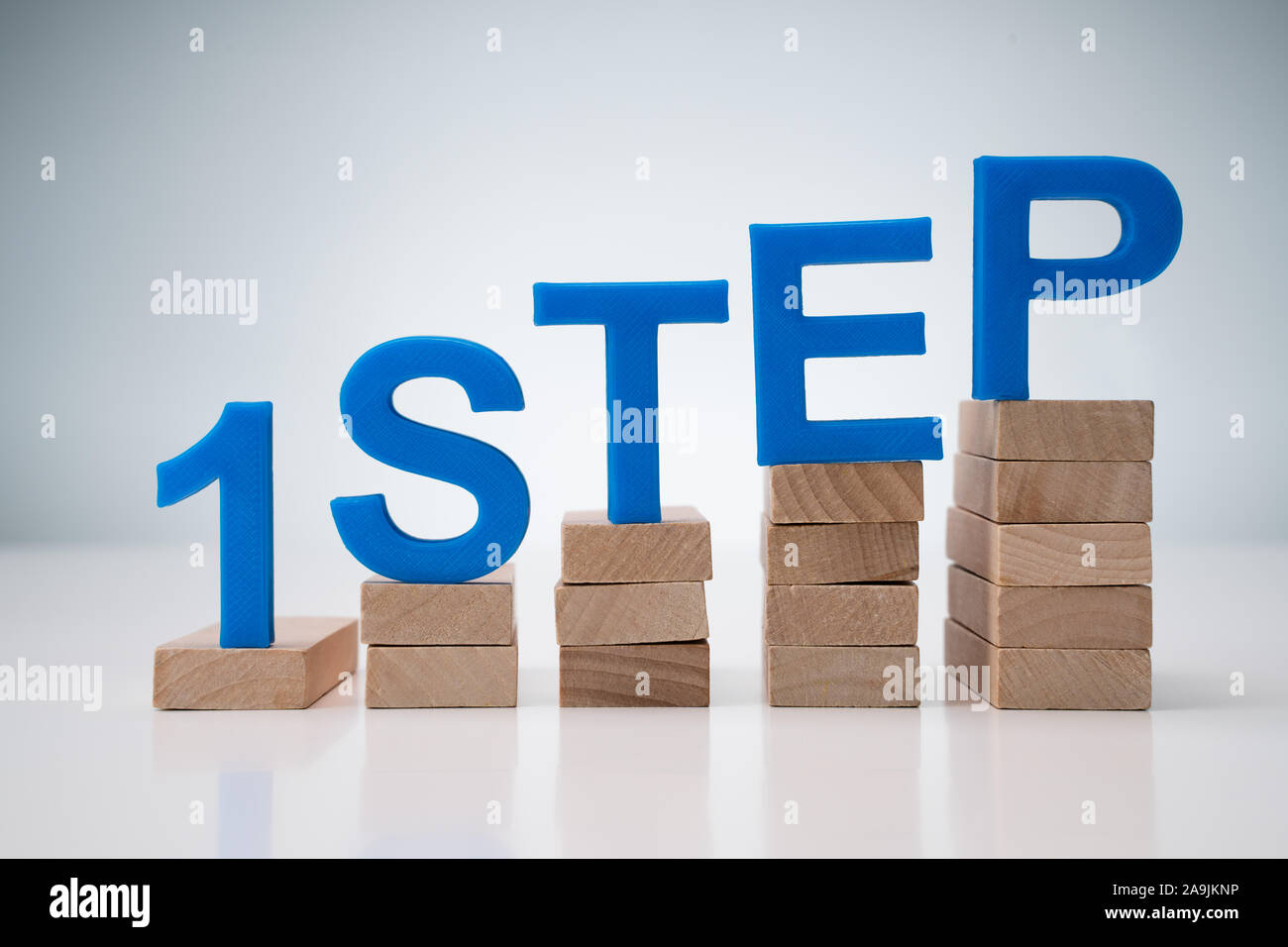 1st Step Letter on Steps Over Gray Background Stock Photo
