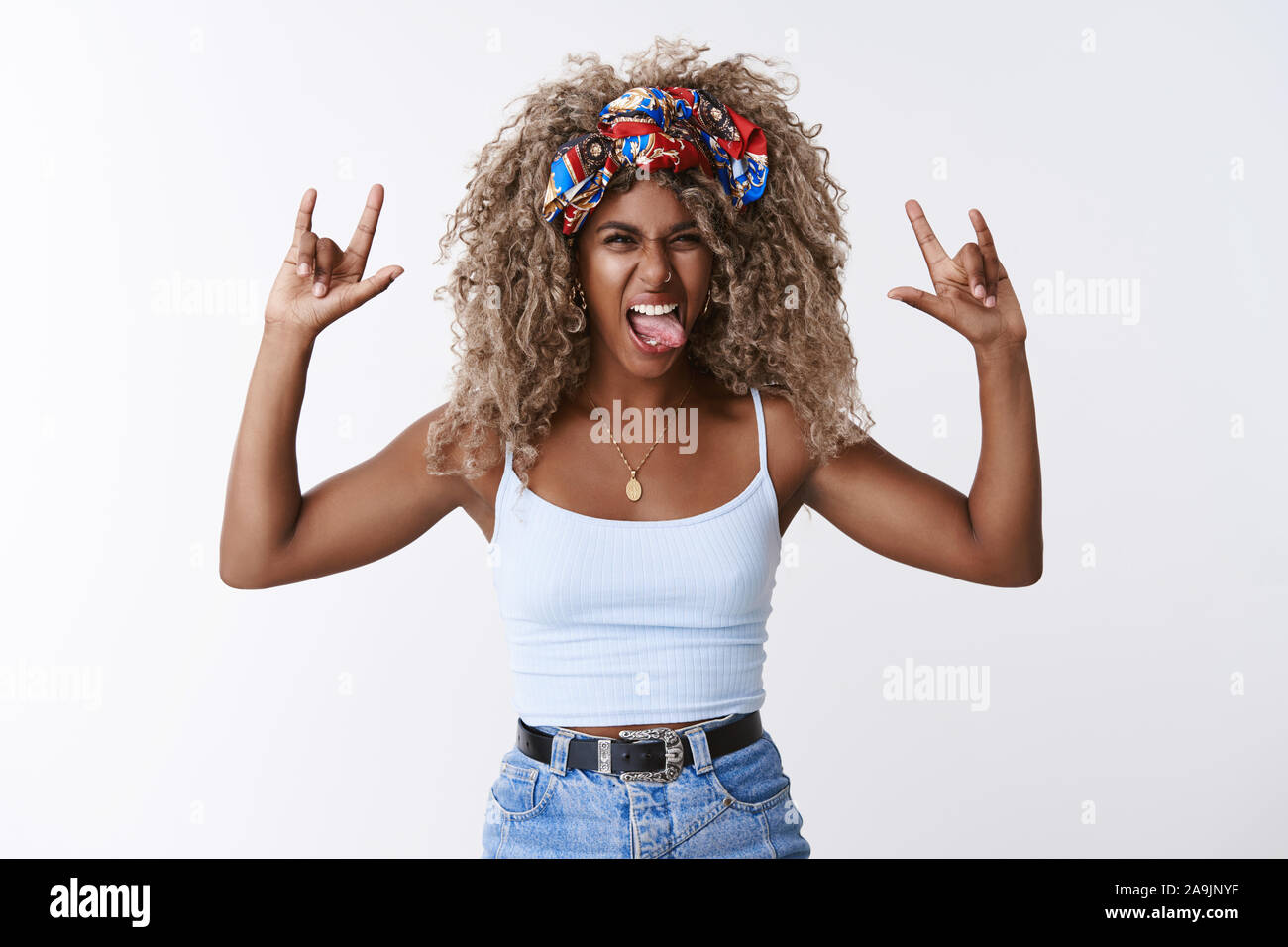 Daring and wild carefree good-looking blond african-american woman, afro  hairstyle, show tongue squinting joyful, make rock-n-roll or heavy metal  sign Stock Photo - Alamy