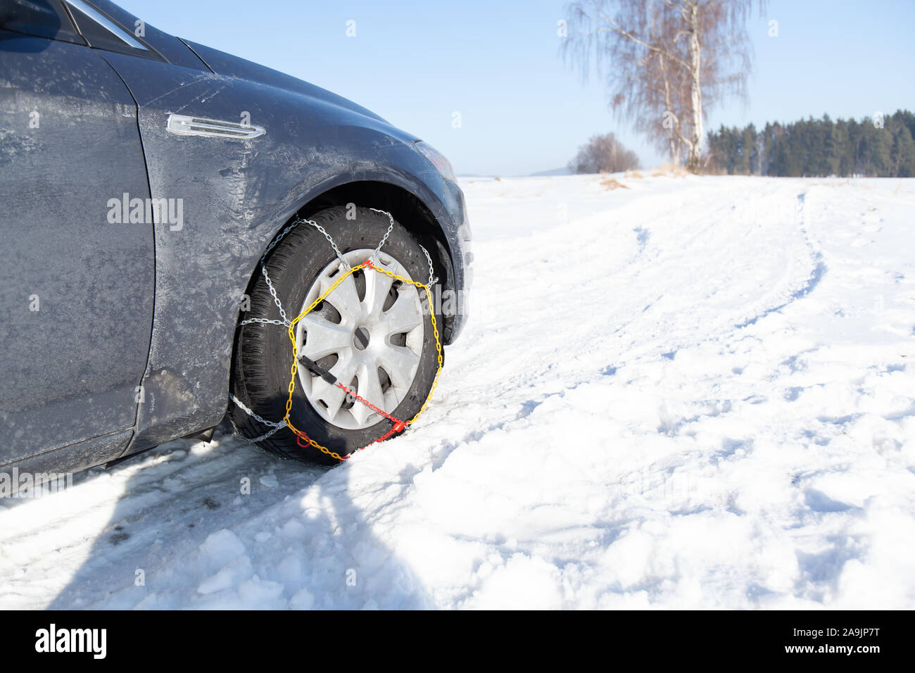 Car stuck in the snow drift. Tire fitted with snow chains Stock Photo
