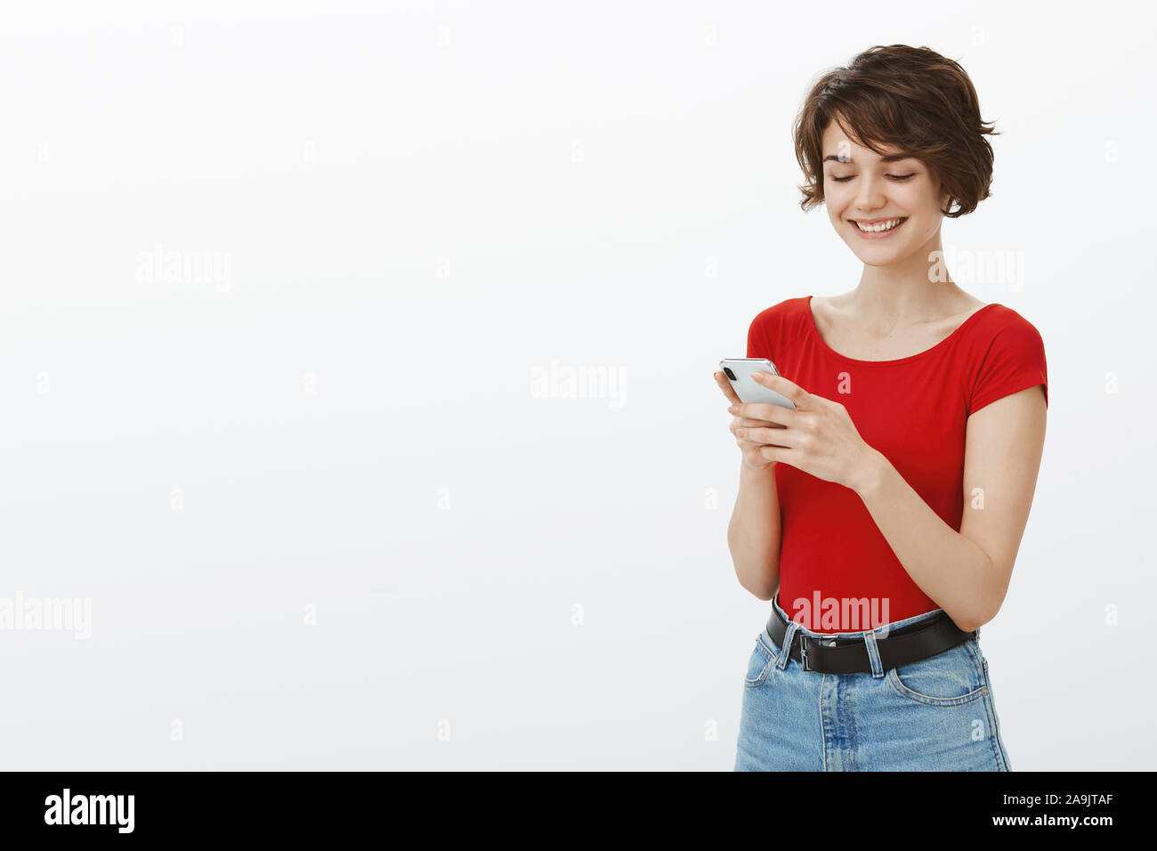 Amused hapyp smiling cute outgoing european girl short haircut hold  smartphone texting friend giggle, funny memes internet reading cool blog  playing f Stock Photo - Alamy