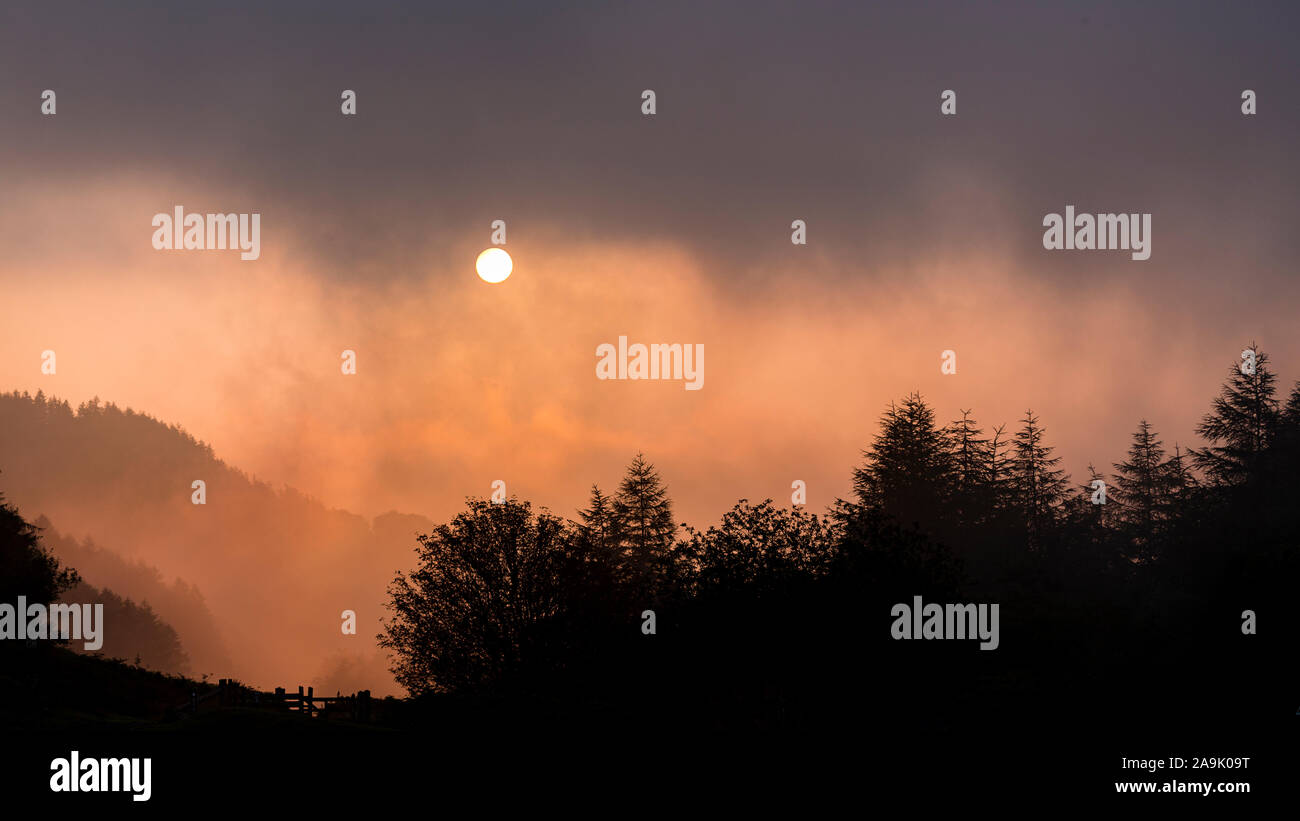 Sunrise though fog over the Clwydian Range, North Wales Stock Photo