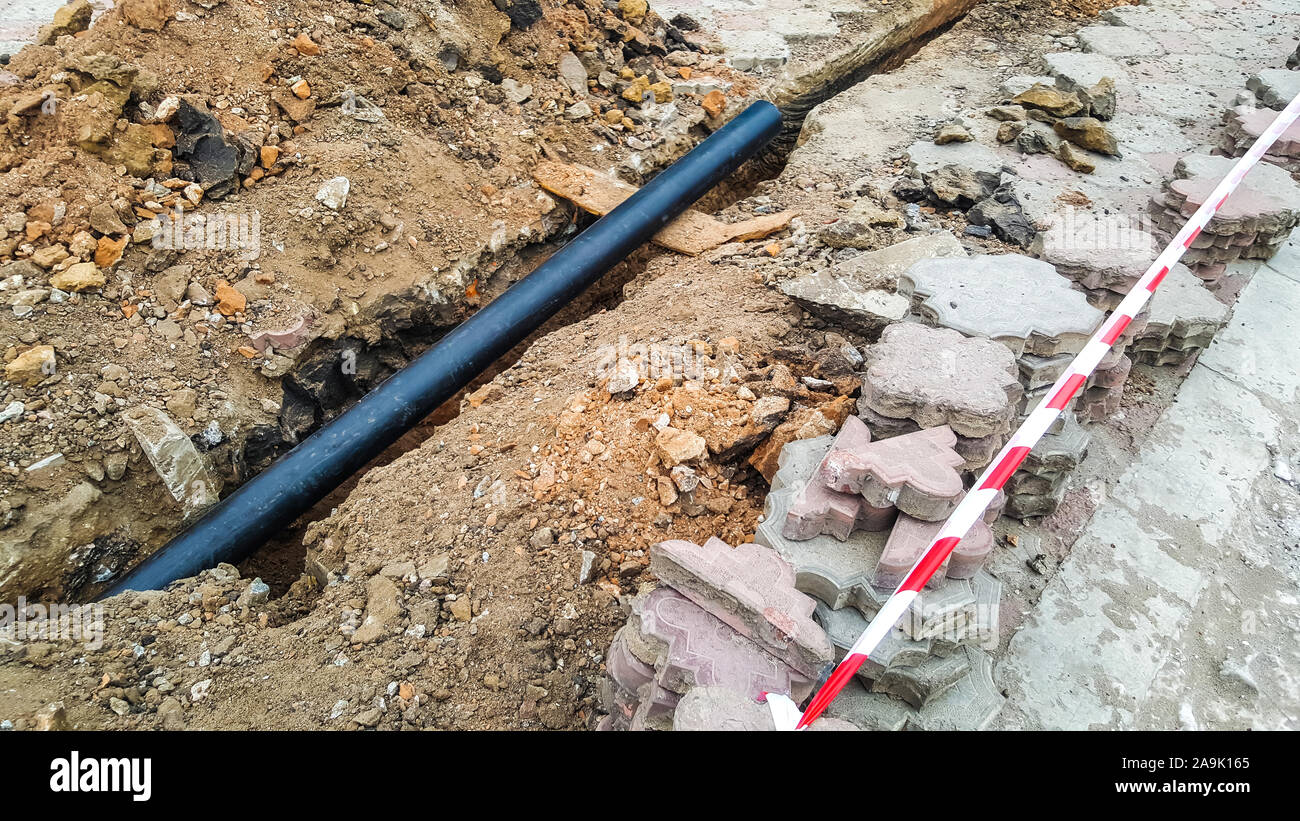 Laying installation of a new cable in a plastic pipe. Digging drilling of the earth for pipe