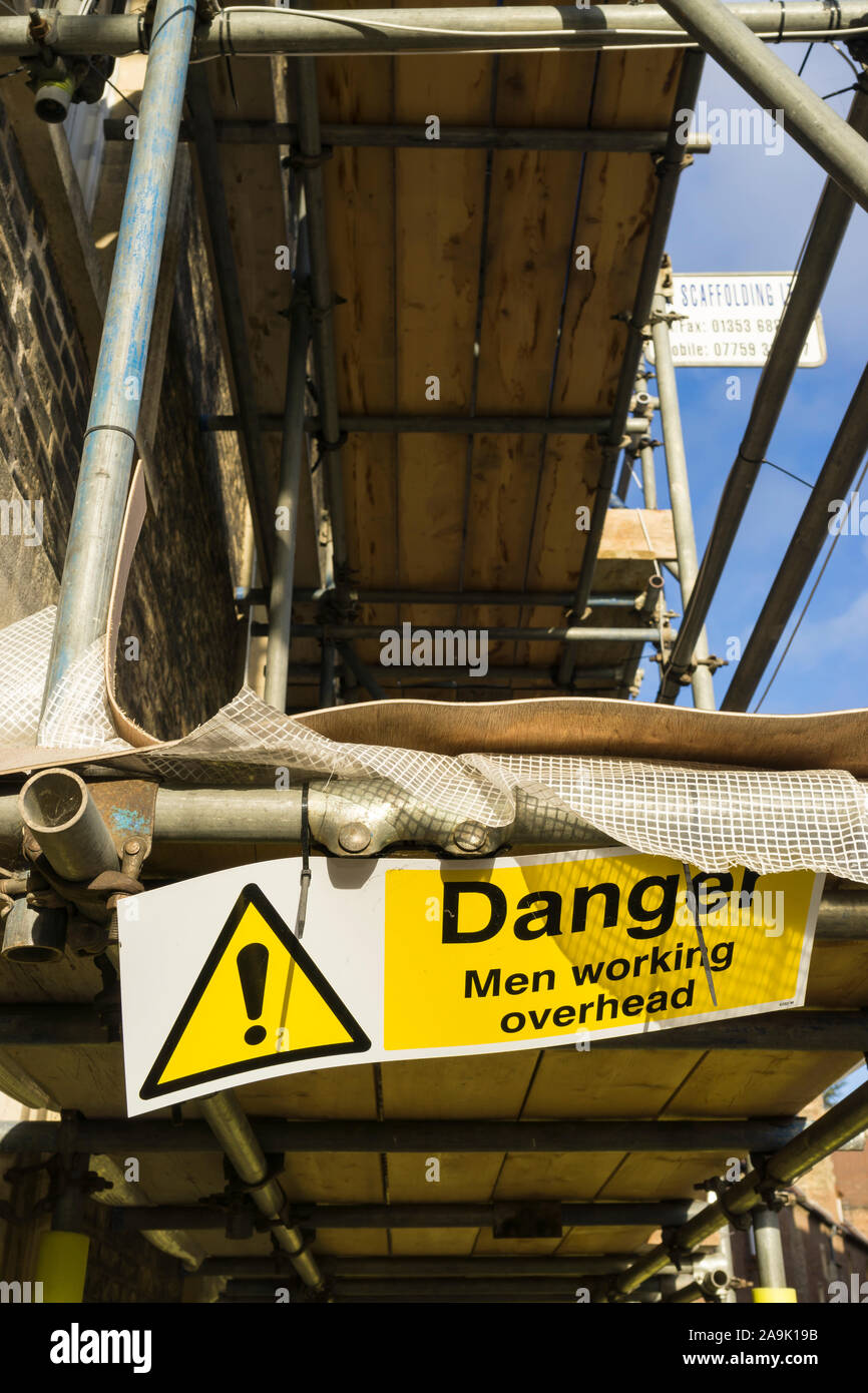Danger sign Men working overhead on scaffolding Stock Photo Alamy