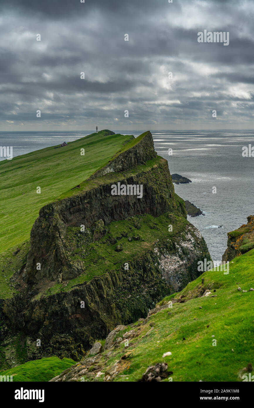 The lighthouse on Mykines island under the clouds, Faroe Islands Stock Photo