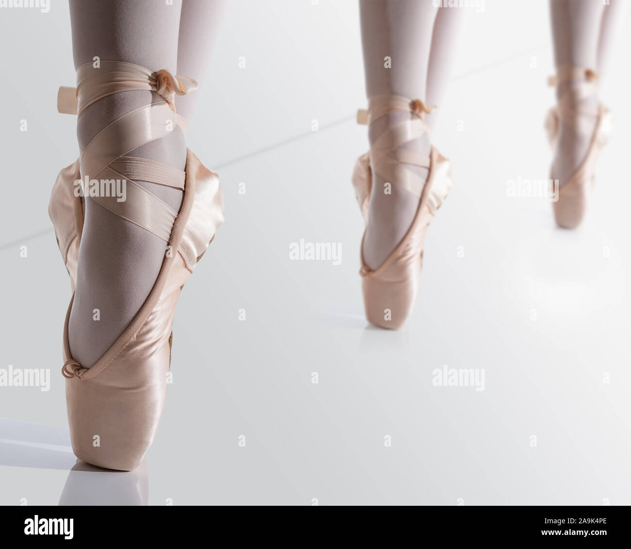 feets with pink satin pointe shoes by a classic ballerina on tiptoe Stock Photo