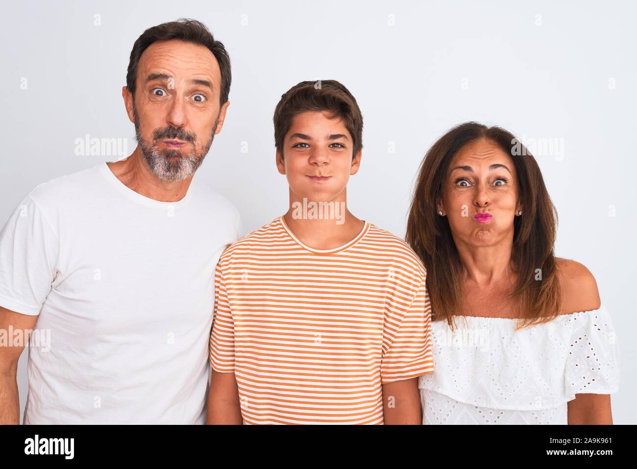 Family Of Three Mother Father And Son Standing Over White