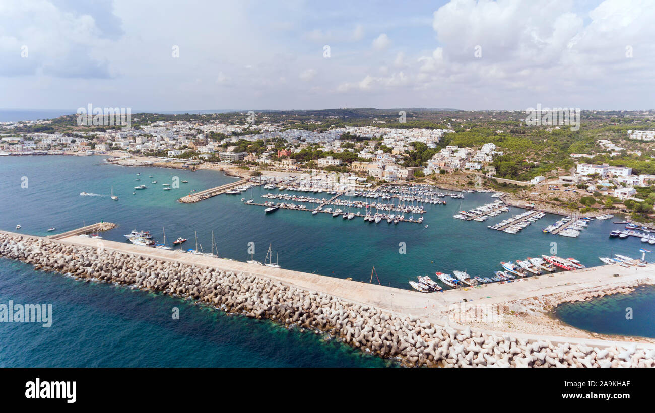 Aerial view of the southernmost point in Salento , town of Santa Maria di Leuca, with boats and in yachts in busy port sheltered by stone barrier . Stock Photo