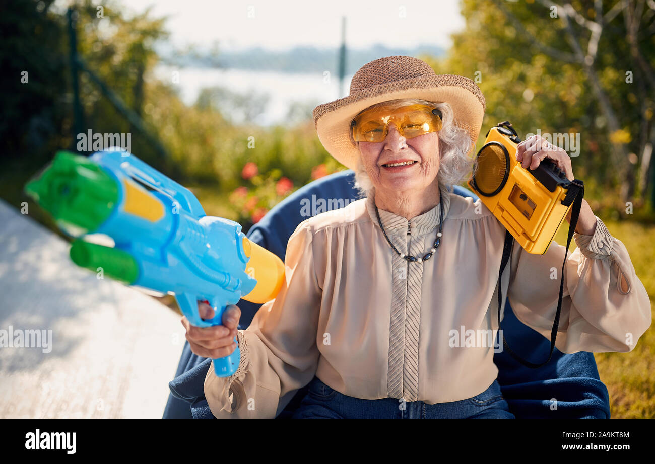 crazy happy senior woman  on  vacation  playing with water gun Stock Photo