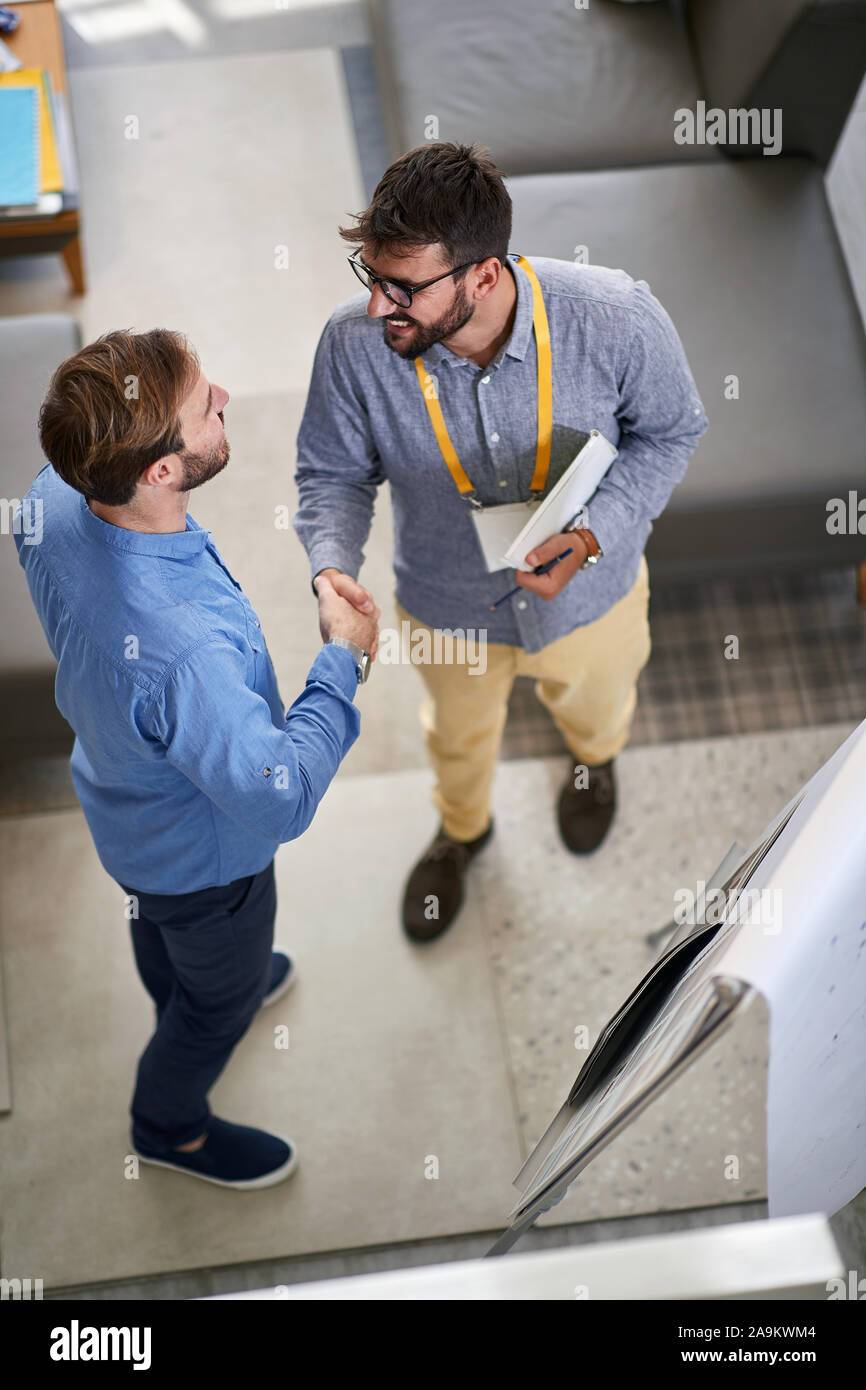Young man customer with salesman in store furniture for the house Stock