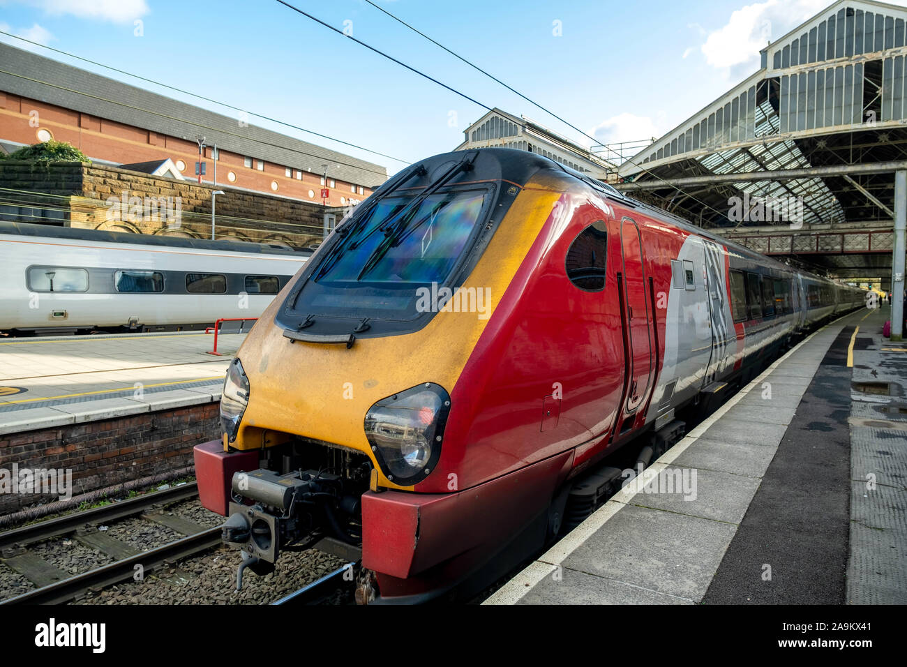 Red and yellow passenger train at the station platform with a clear ...