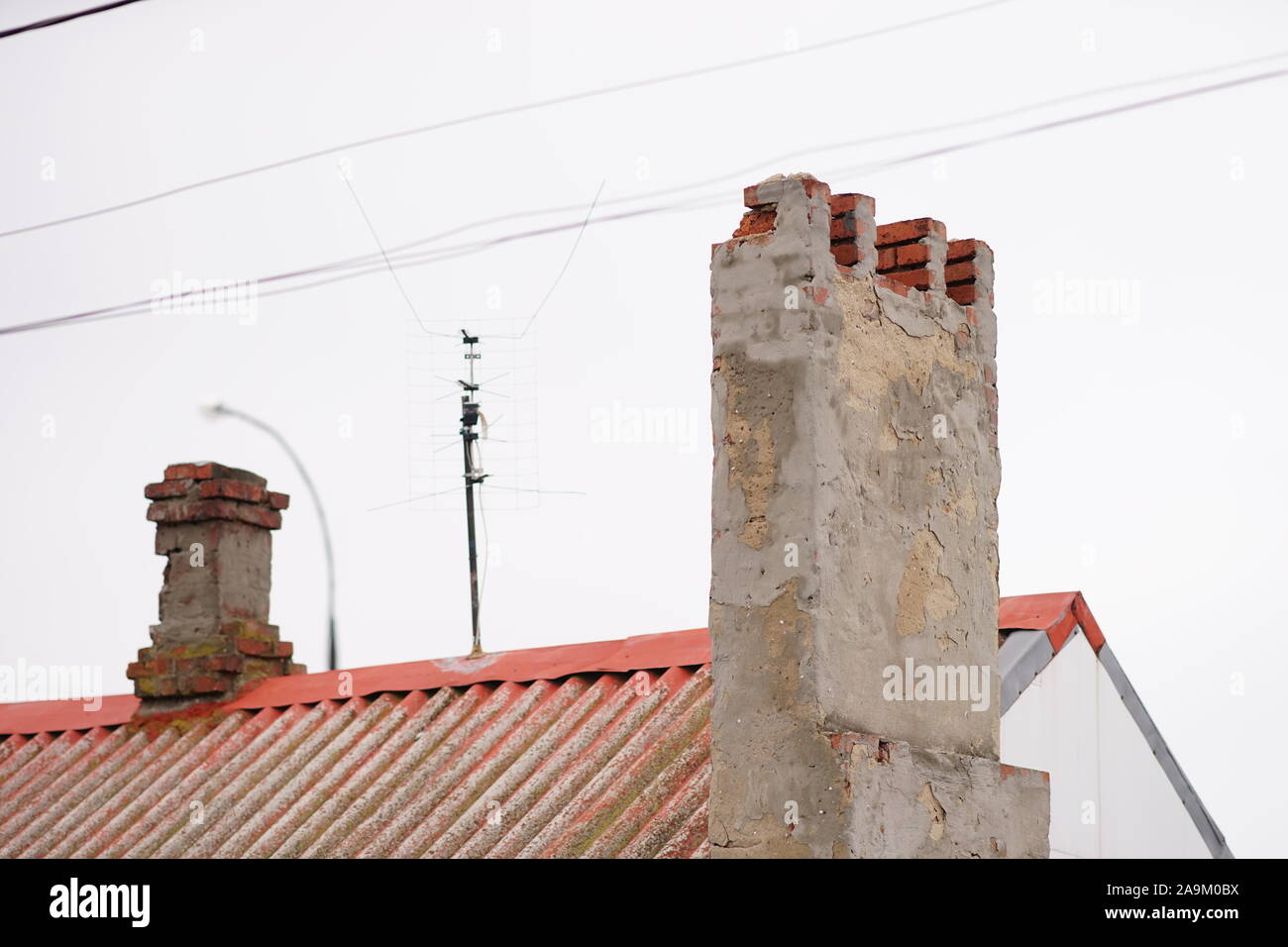 Two old destroyed chimneys on a rural roof Stock Photo