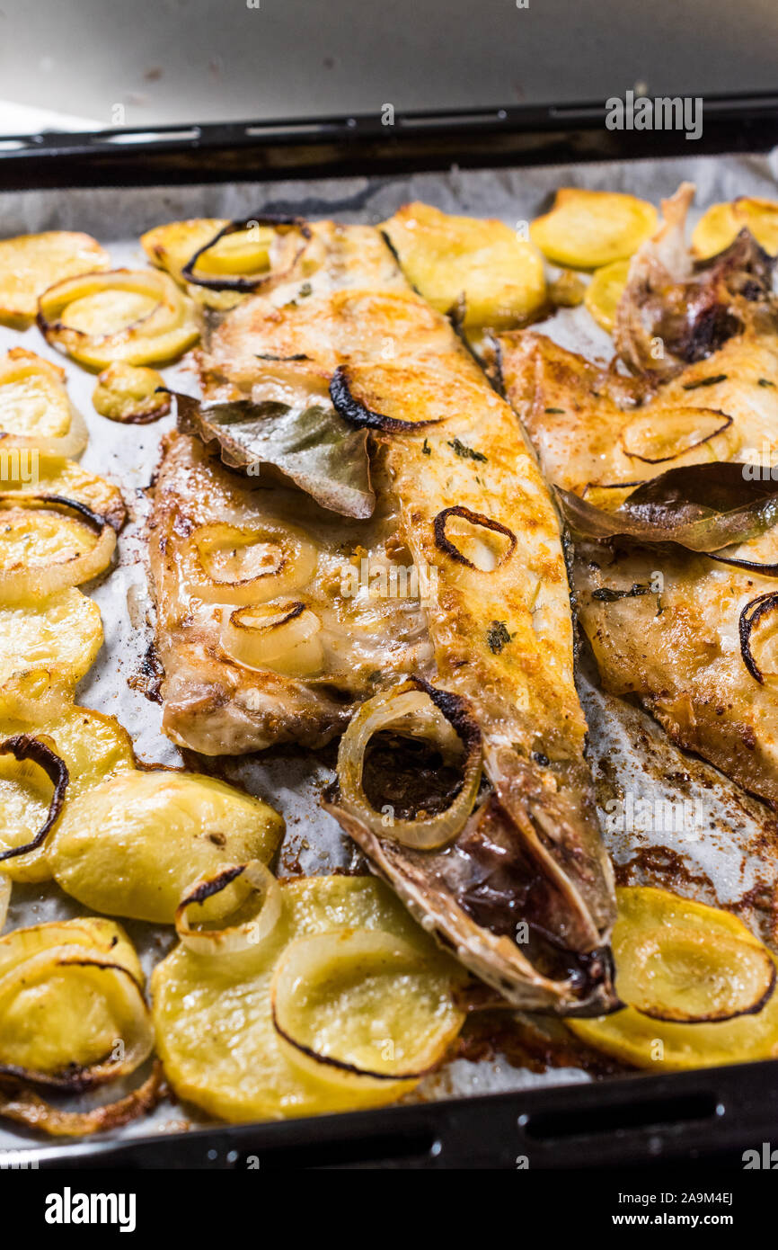 Fillet of Sea Bass Grilled with Potatoes and Onions in Baking Tray with Oven. Organic Food. Seafood. Stock Photo