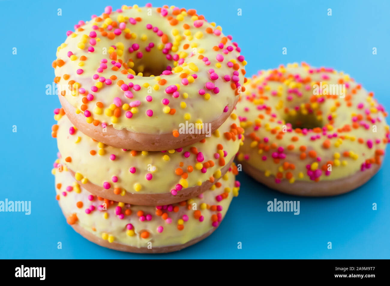 Donuts with sprinkles on blue background. Pile of colorful donuts Stock ...