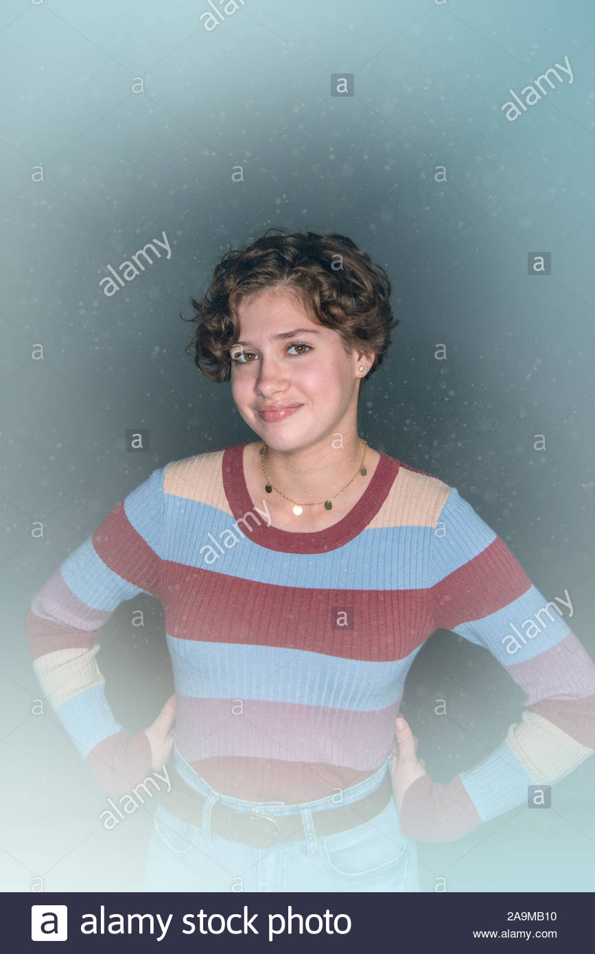 Teenage Girl With Short Brown Curly Hair Models Fashions In Studio