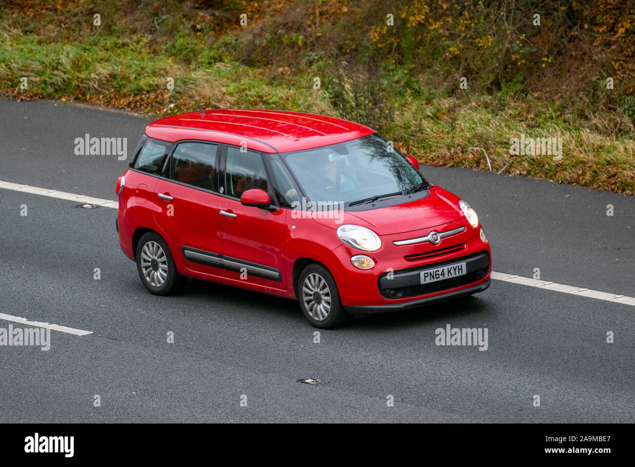 2014 red Fiat 500L MPW POP Star; UK Vehicular traffic, transport, modern vehicles, saloon cars, south-bound on the 3 lane M61 motorway highway. Stock Photo