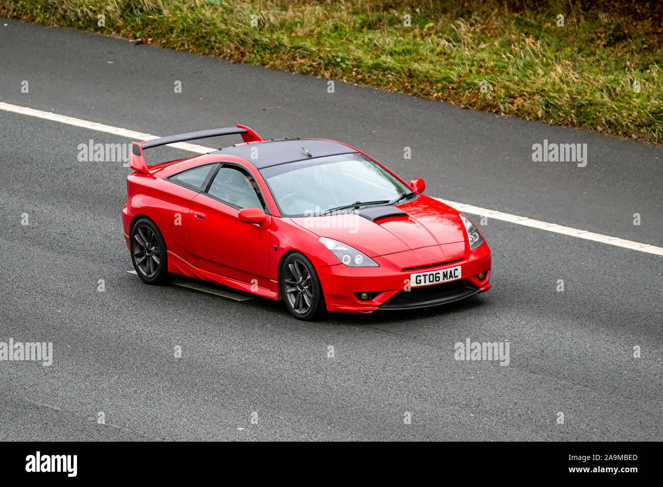 2006 red Toyota Celica Vvtl-I GT; UK Vehicular traffic, transport, modern vehicles, saloon cars, south-bound on the 3 lane M61 motorway highway. Stock Photo