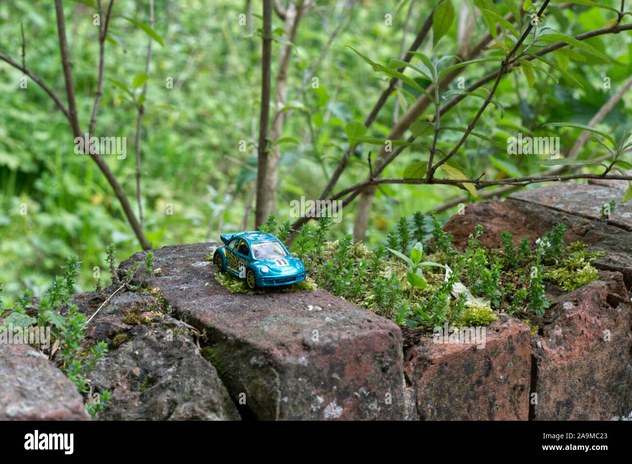 Child's toy beetle on a wall in the woodlands Stock Photo