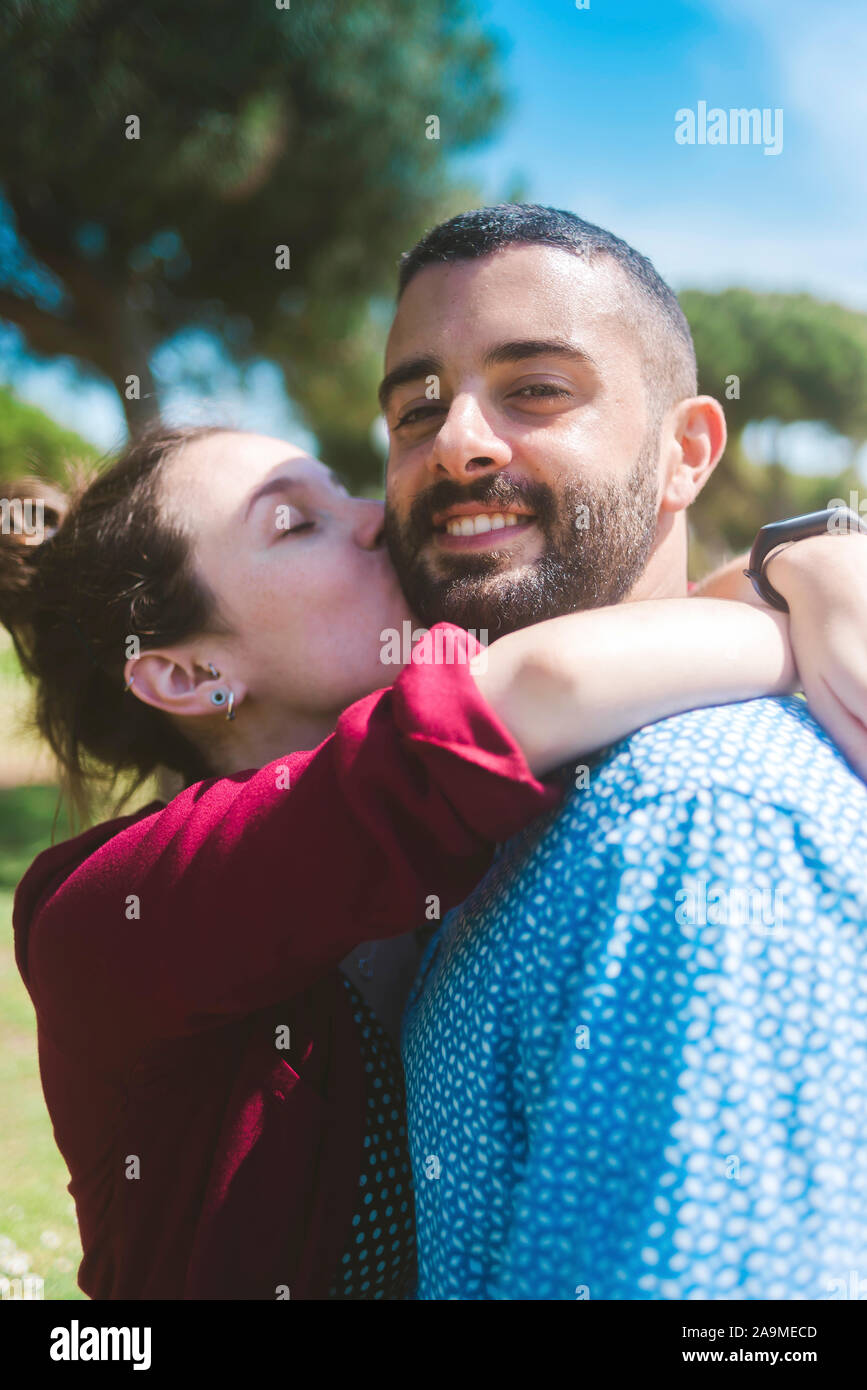 Happy couple kissing and hugging in the park Stock Photo - Alamy