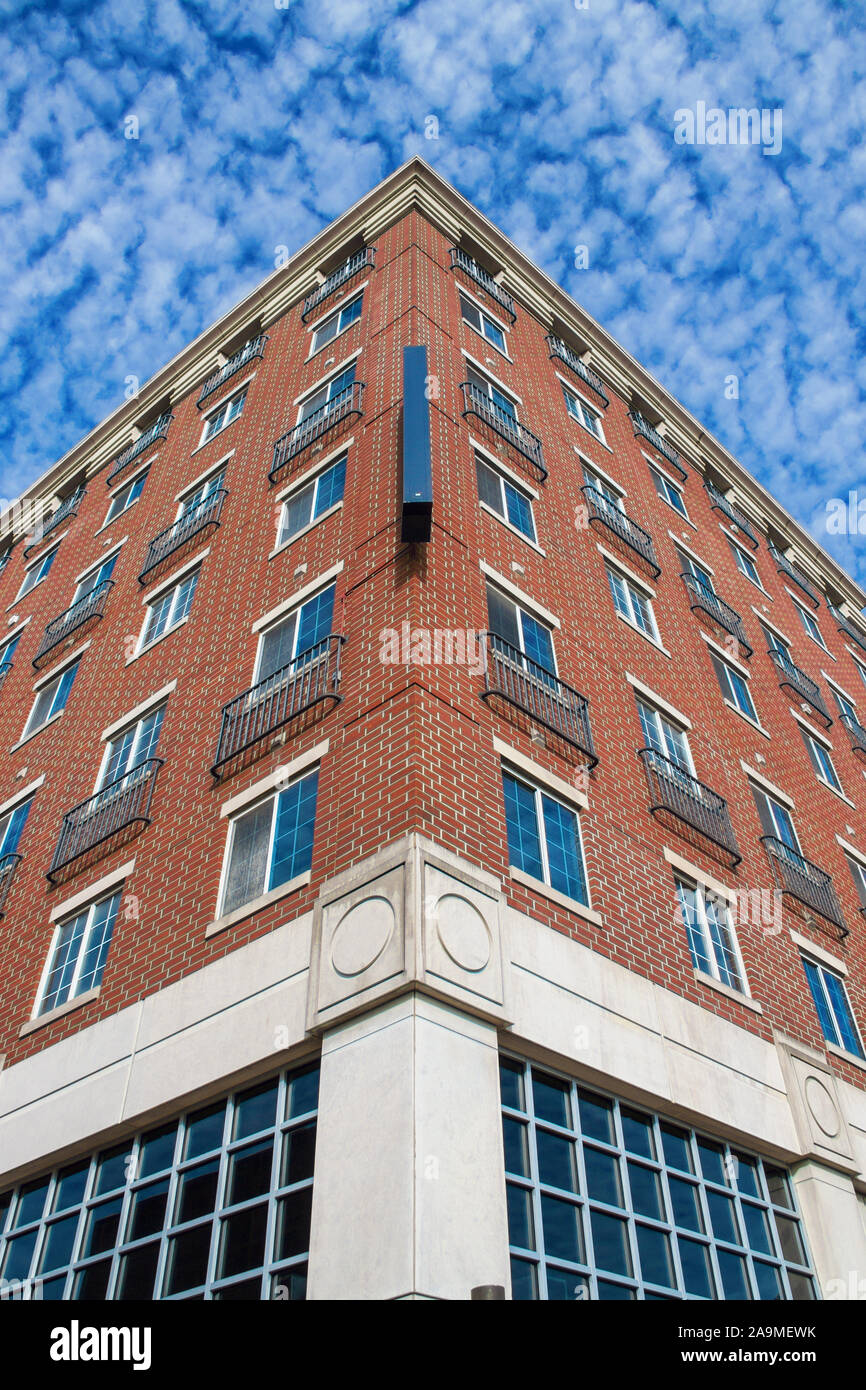 Perspective of tall brick attractive middle America business building from corner with crazy puffy blu of tall brick attractive middle America busines Stock Photo