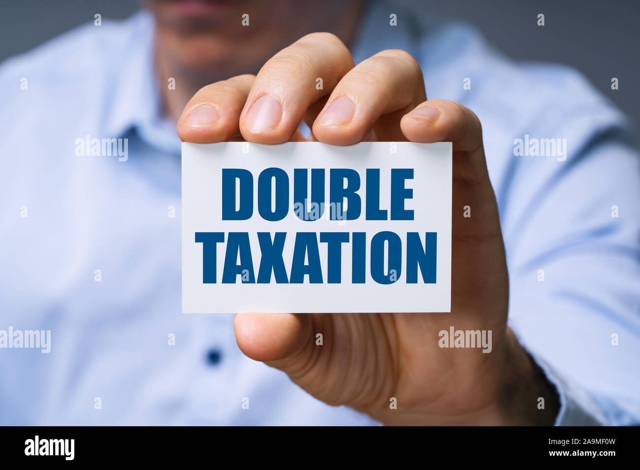 Man Showing Card With Double Taxation Text Stock Photo