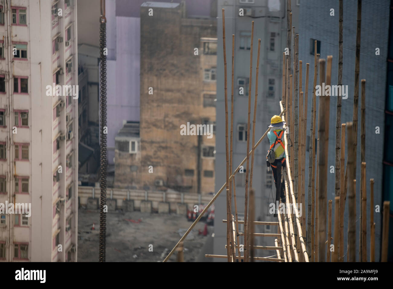 Bamboo scaffolding in Hong Kong at the top of a skyscraper under development with workers who clearly do not suffer from vertigo Stock Photo