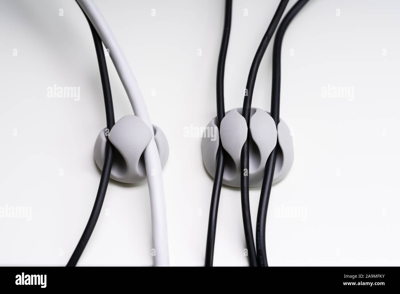 Close-up Of A Sticky Cable Holder On White Surface Stock Photo