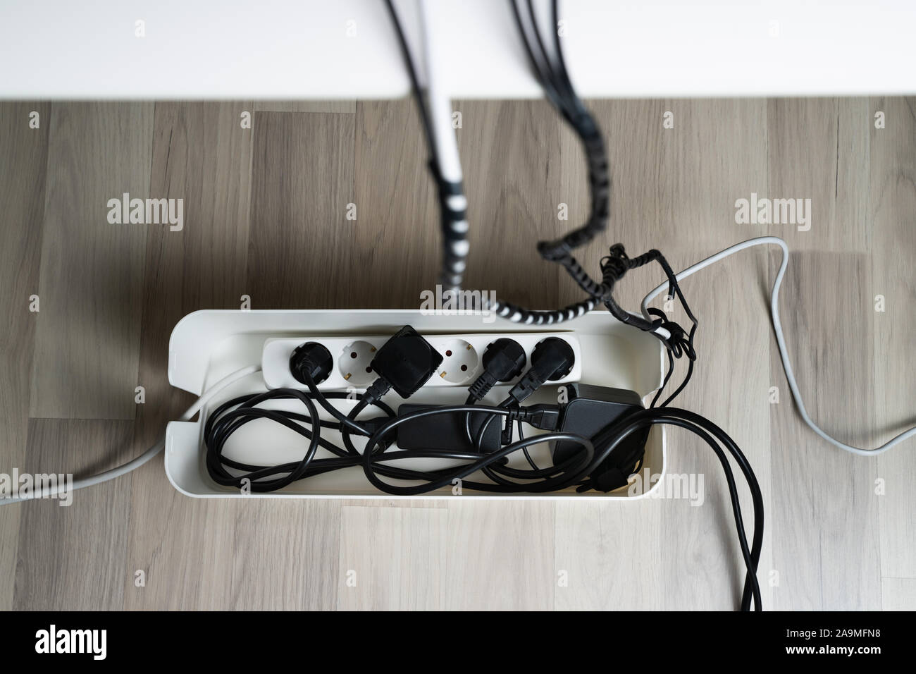 High Angle View Of Cable Management Box With Cables On Hardwood Floor Stock Photo