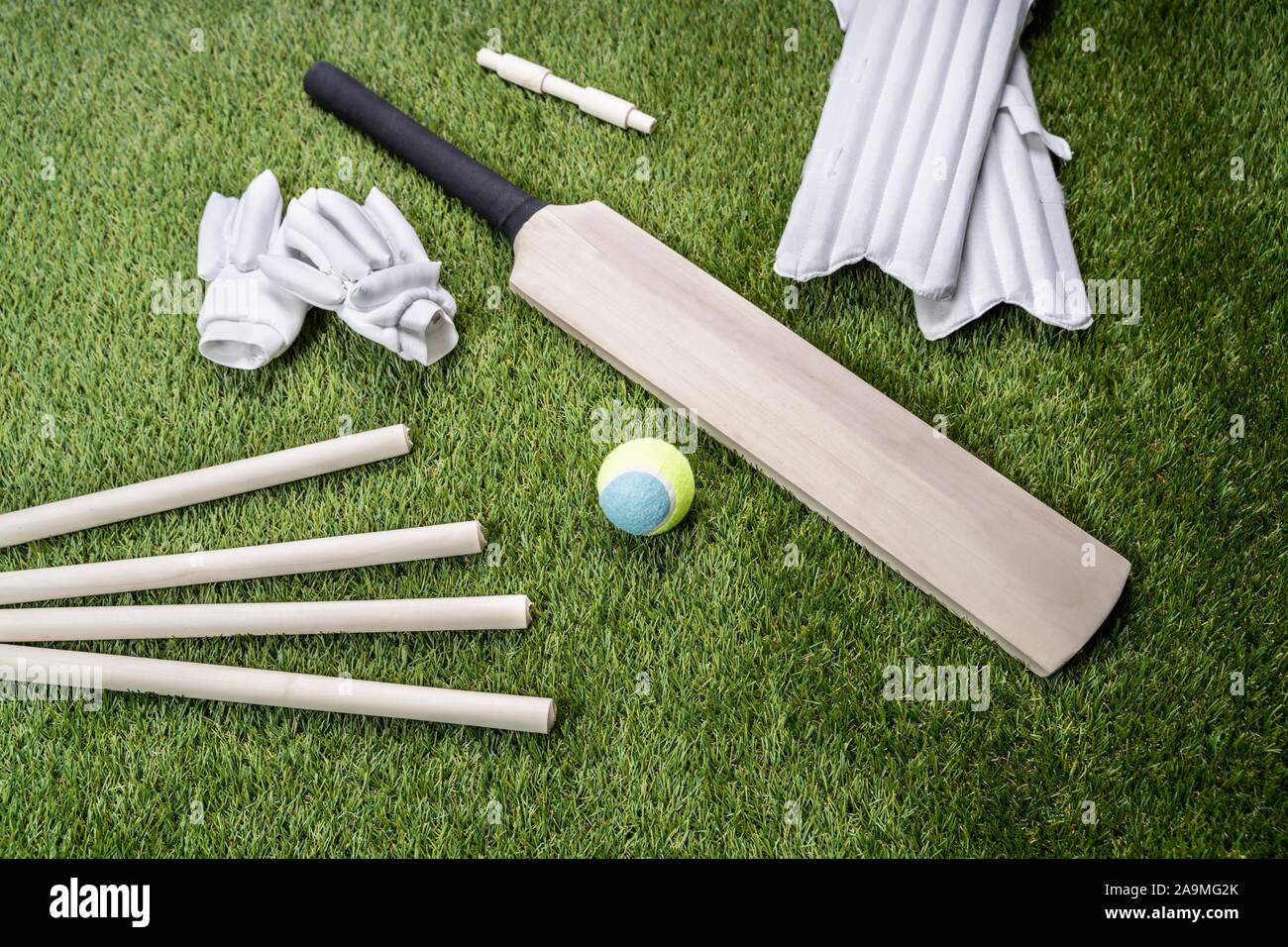 Close-up Of Wooden Cricket Bat And Ball On Turf Grass Stock Photo