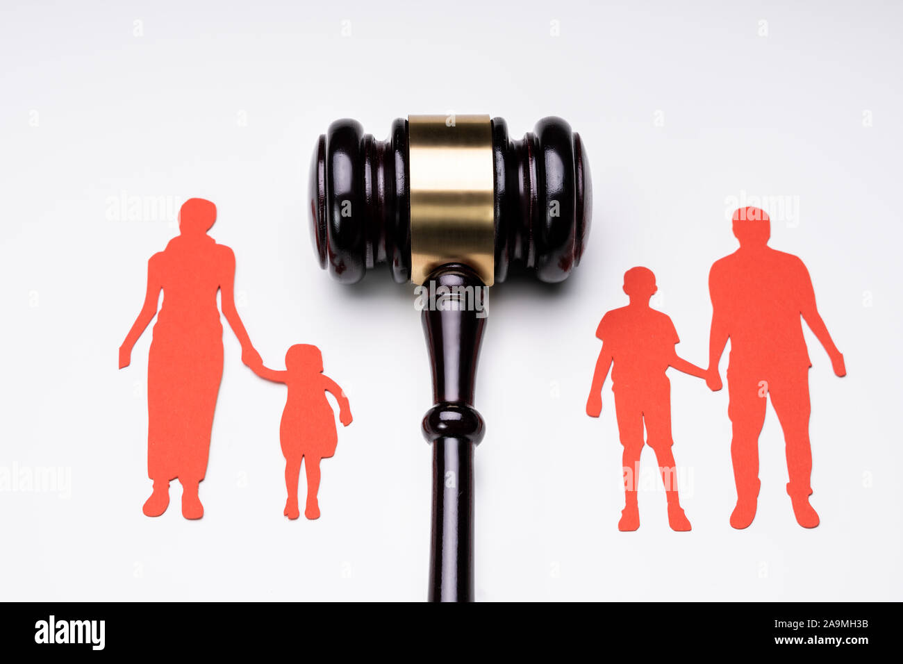 Separated Family Figure Paper Cutout And Judge Gavel Over White Surface Stock Photo
